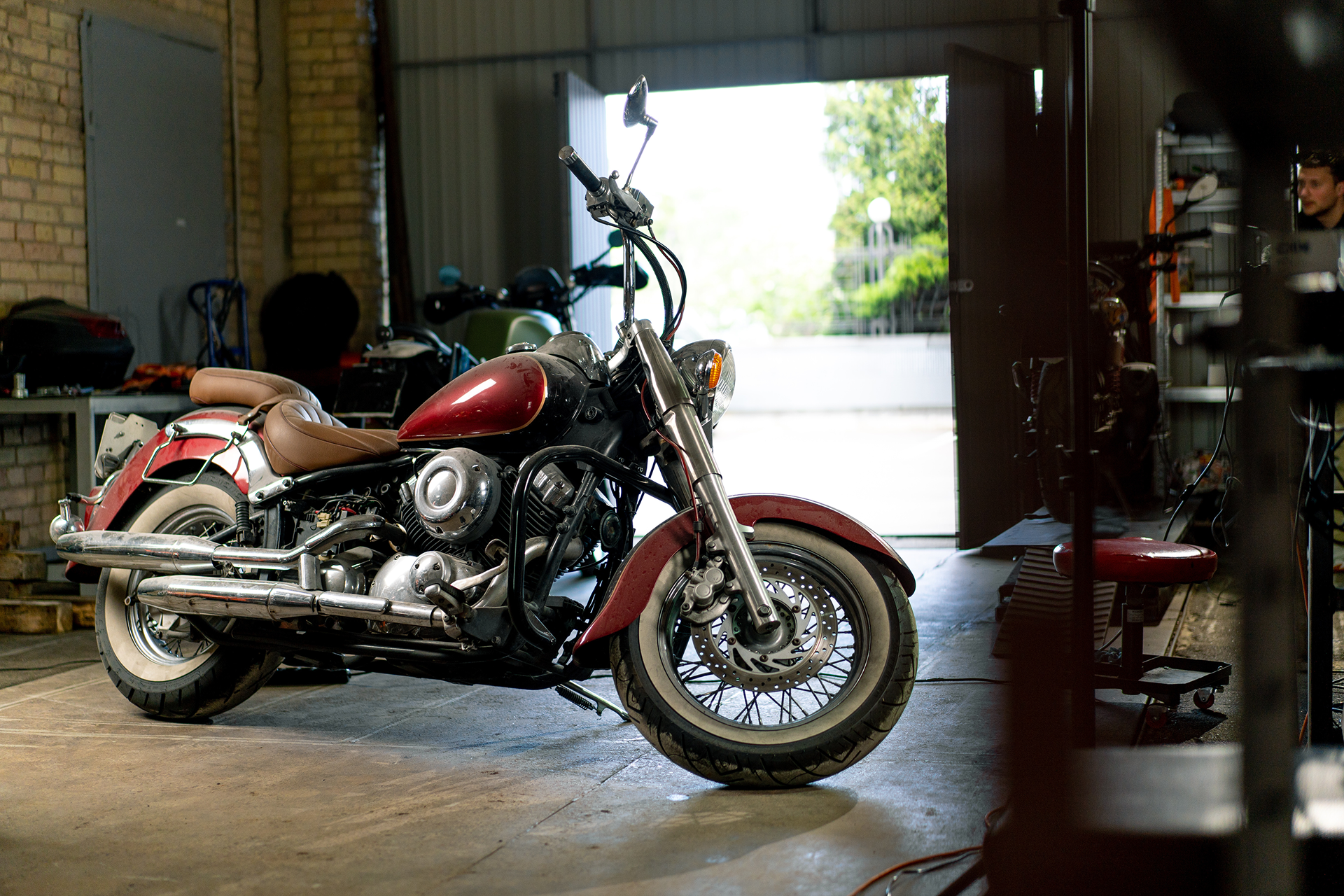 A red motorcycle in a garage workshop