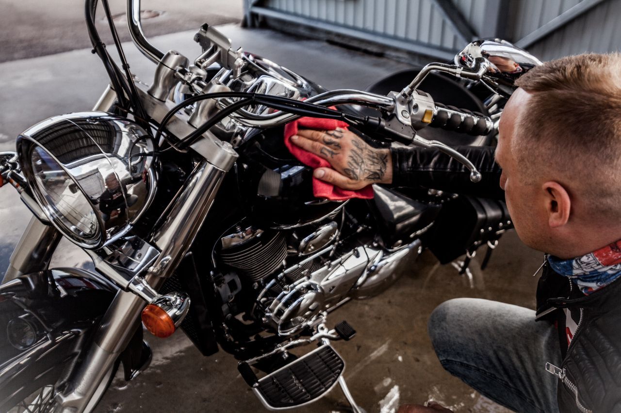 man wiping down a motorcycle man wiping down a motorcycle