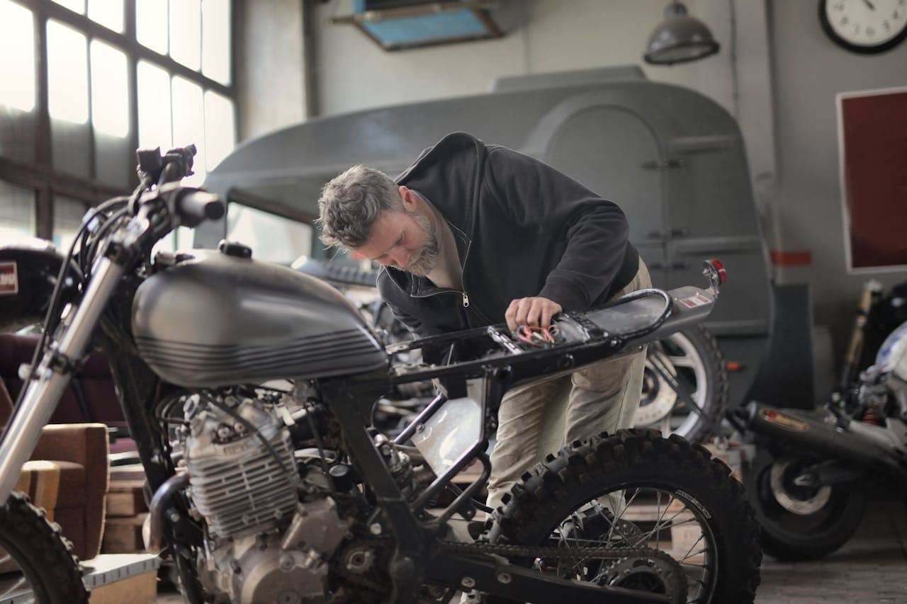 A man working on a custom motorcycle in a garage