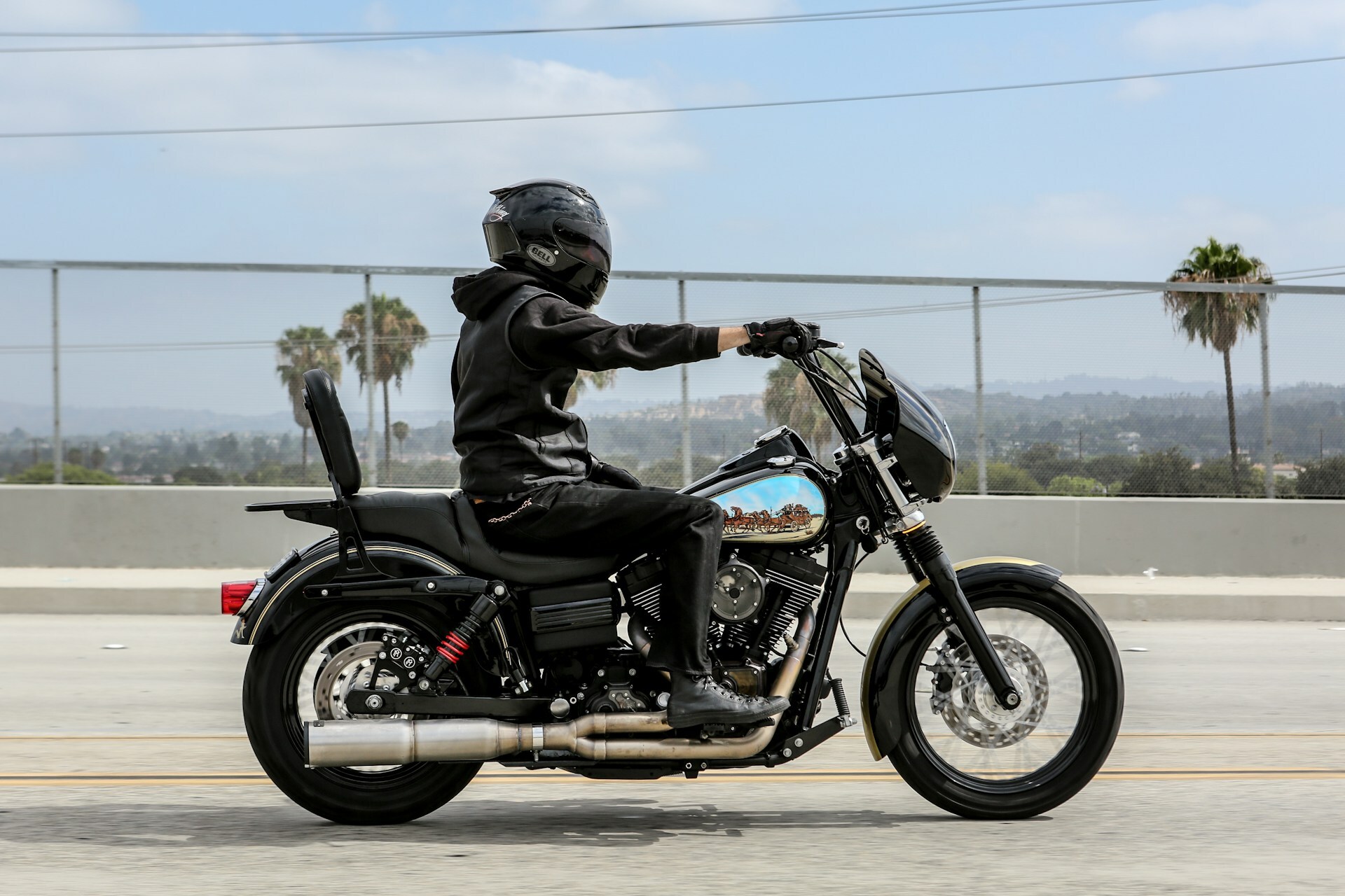 Rider cruising on motorcycle with aftermarket exhaust system