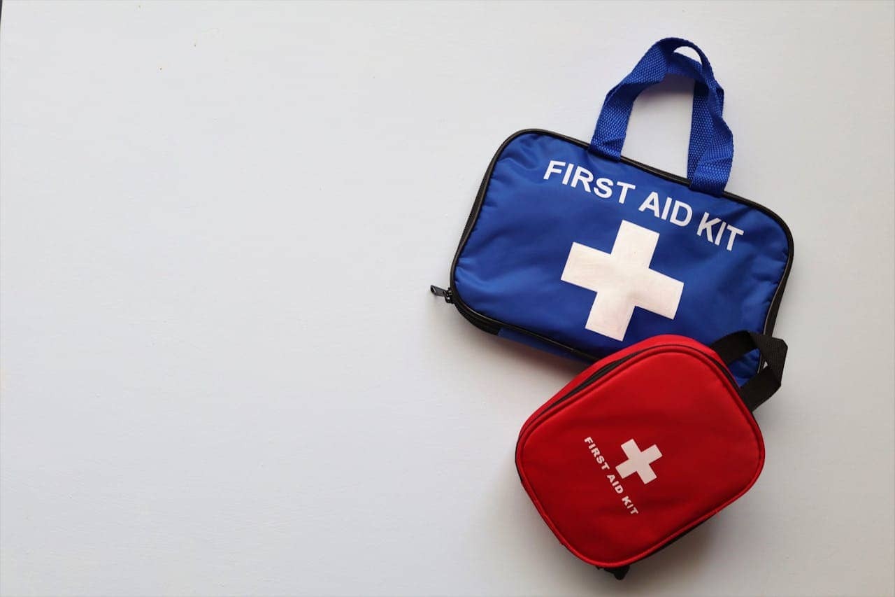 Two first aid kits on a light gray surface